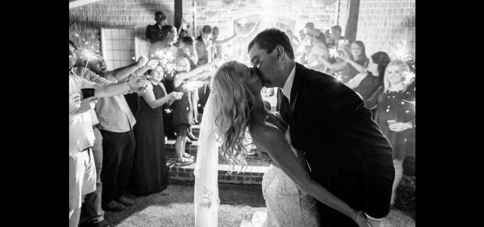 black and white photo of a groom kissing his bride 